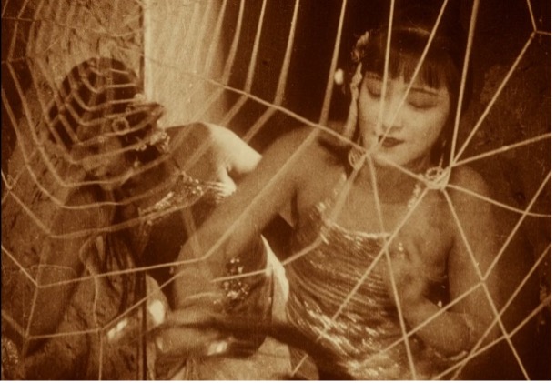 Two women standing behind a large spider web